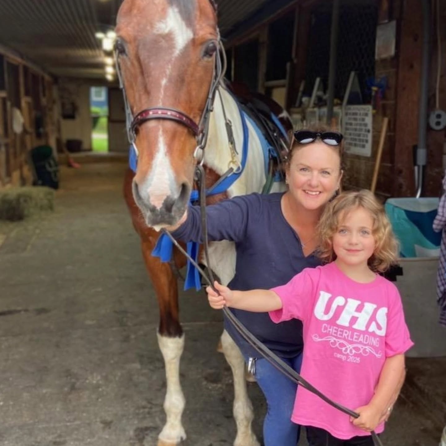 Woman and child with horse in stable